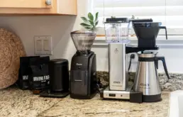 Coffee grinder and drip coffee makers arranged on a kitchen counter